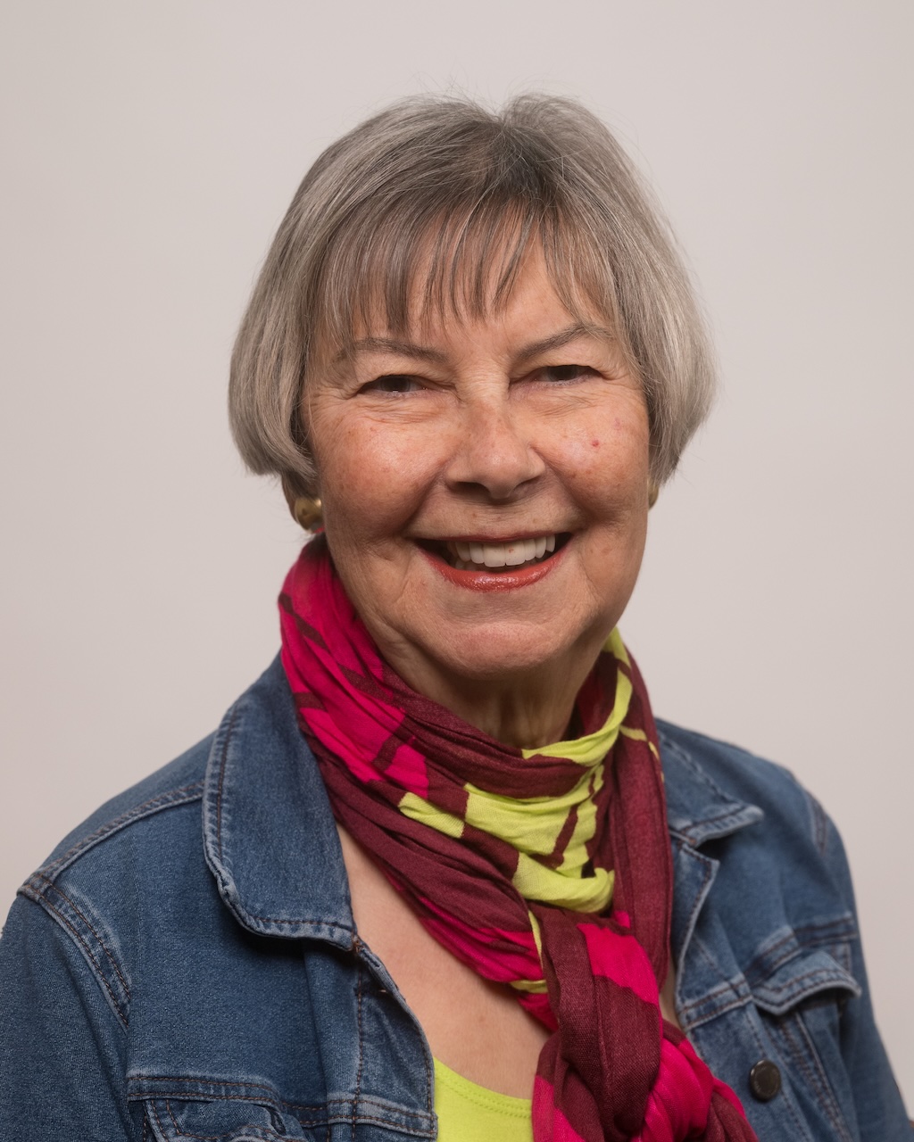photograph of Charlotte Morganti, wearing blue jean jacket and red/green scarf